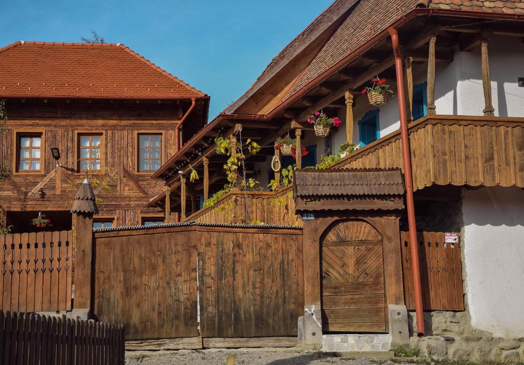 una casa con una puerta de madera y una valla en Székelyföld ,Siklódi Kő Vendégház, Tornácosház en Bartostanya