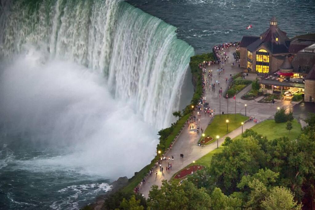 a large waterfall with a crowd of people standing in front of it at Renovated Home - Walk to Falls & Tourist District in Niagara Falls