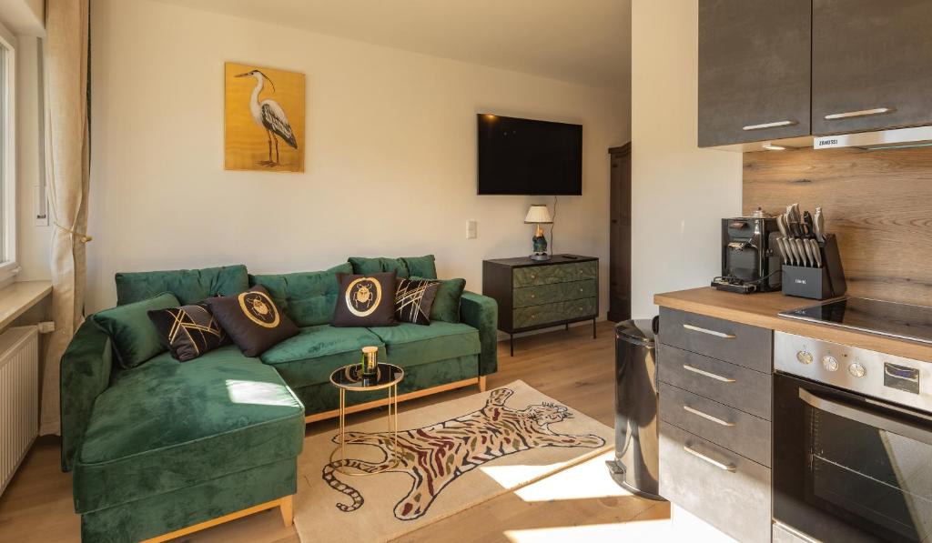 a living room with a green couch and a tv at SweetHome - Luxus pur - Küche, Balkon, WiFi in Dachau