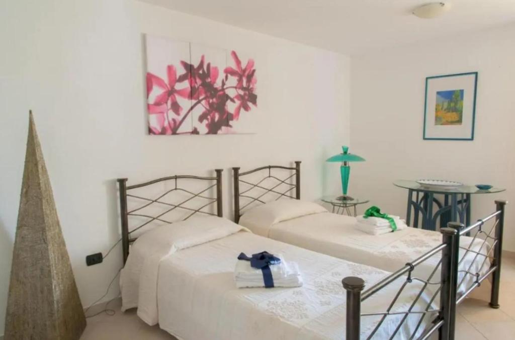 2 camas individuales en una habitación con una foto en la pared en Casa Vacanza Le Fresie, en Nuoro