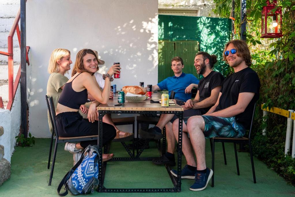 un groupe de personnes assises à une table dans l'établissement Meiga Backpackers Hostel, à Saint-Jacques-de-Compostelle