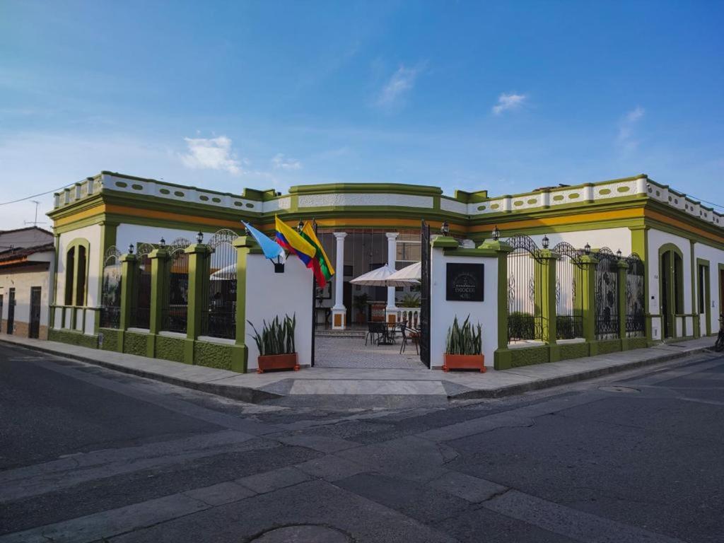 a building with flags in front of a street at HOTEL EVOCACIÓN in Buga