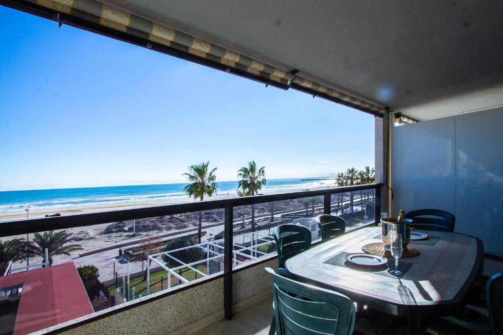 a balcony with a table and chairs and a view of the beach at ESPACIO 2 Primera LINEA DE PLAYA in Cullera