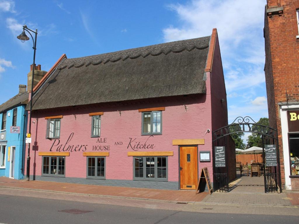 a pink building on the side of a street at Palmer's Ale House in Long Sutton
