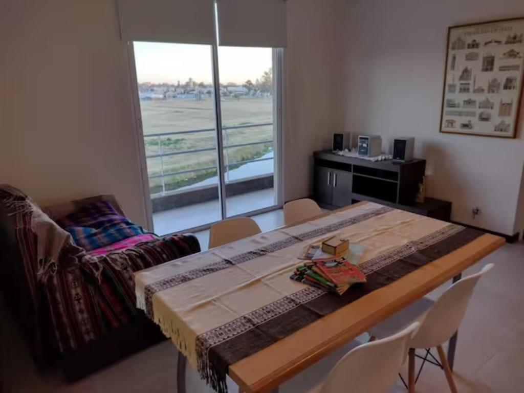 een kamer met een tafel en stoelen en een raam bij Residencia Merlo in Rafaela