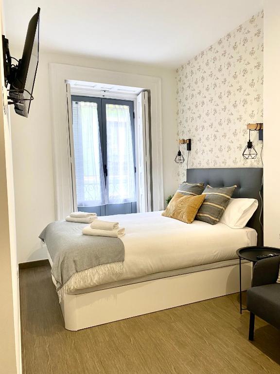 a bedroom with a large bed and a window at Apartamentos Fuencarral in Madrid