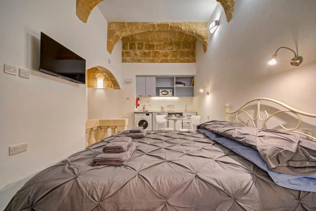 een slaapkamer met een groot bed in een kamer bij 33 Sally Port in Valletta