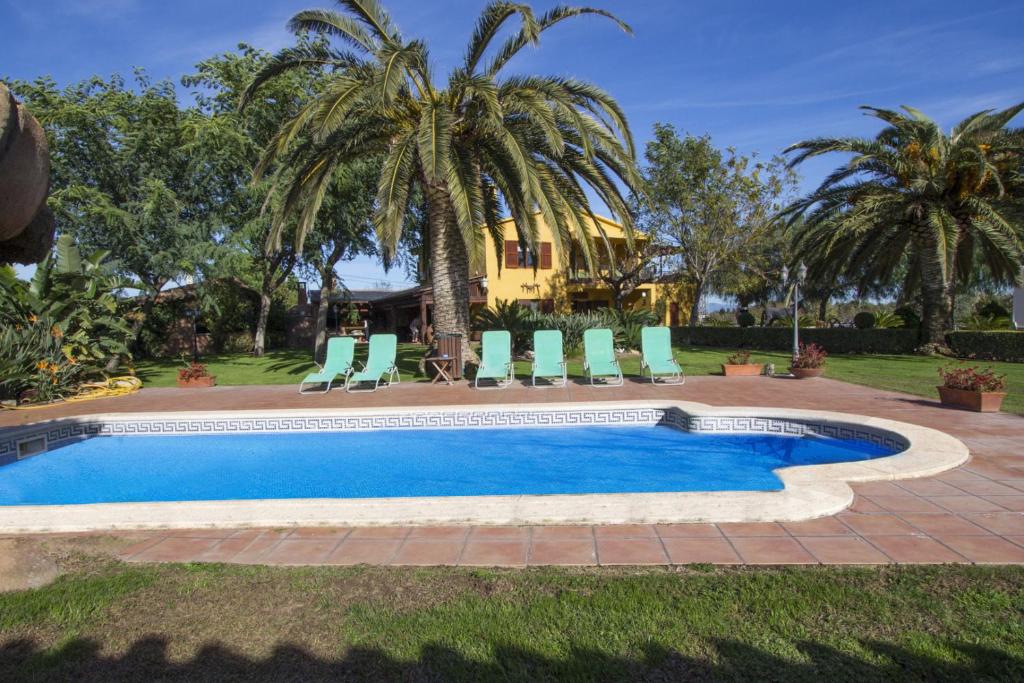 a swimming pool with chairs and a palm tree at Catalunya Casas Incredible secluded villa, just 11km from Beach! in La Selva del Camp