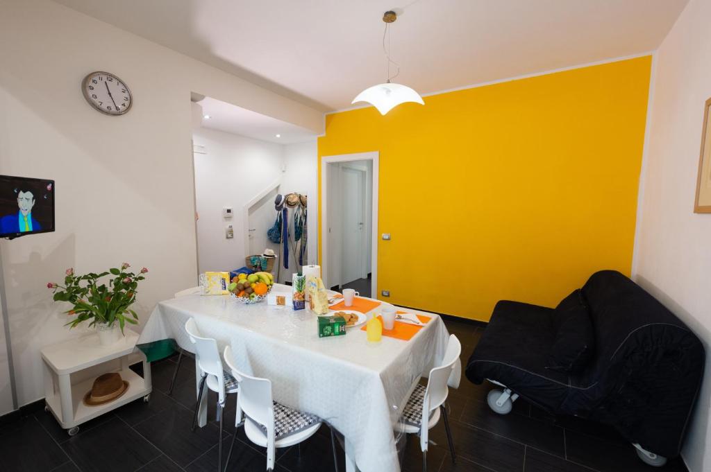 a dining room with a white table and a yellow wall at Vacanze a Casa Pozzallo in Pozzallo