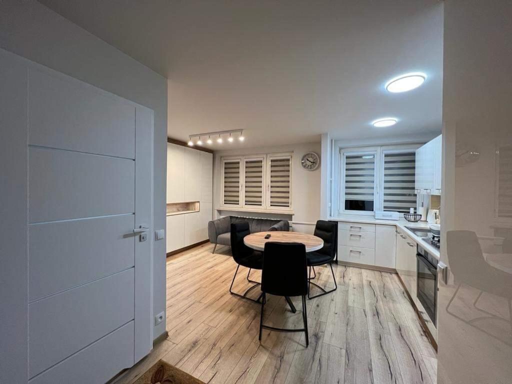 a kitchen with a table and chairs in a room at MW3 Apartament in Rzeszów