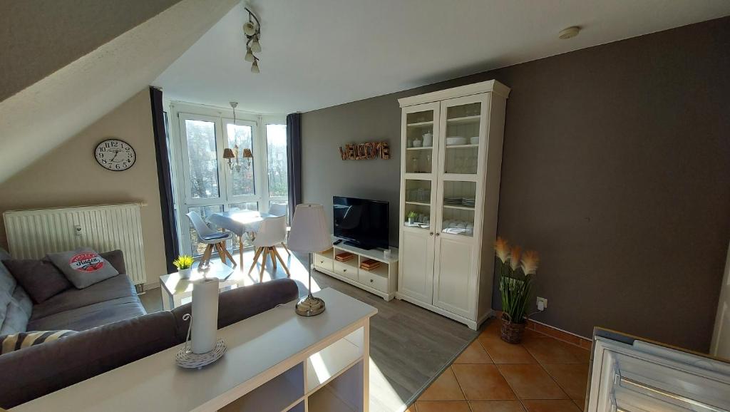 a living room with a couch and a television at Ferienwohnung Ostsee-Buhne Baabe in Baabe