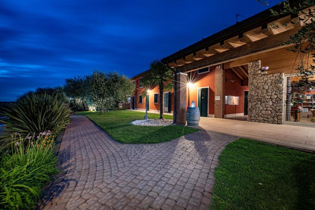 a brick walkway in front of a building at night at Agriturismo Le Tese in Colà di Lazise