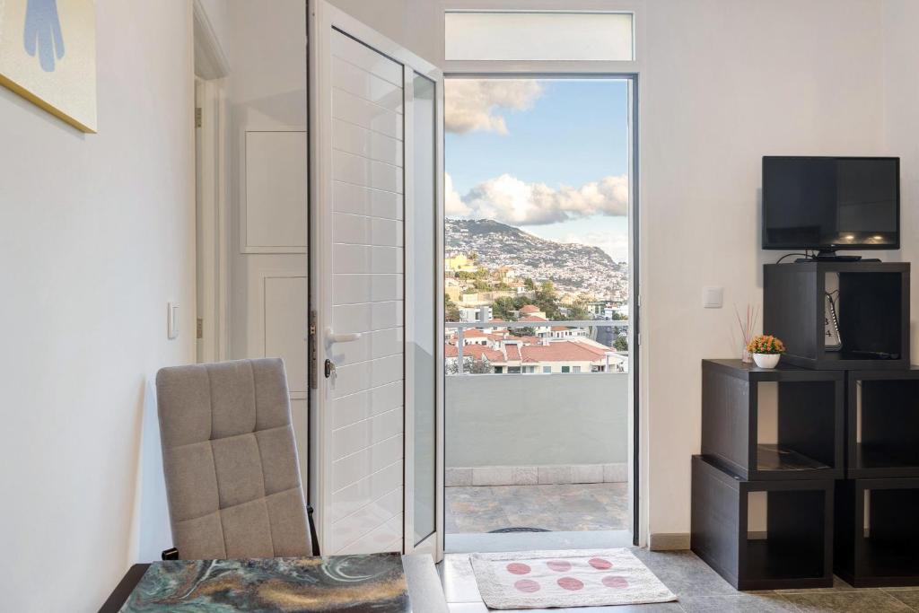 um quarto com uma porta de vidro deslizante e vista em Funchal House no Funchal