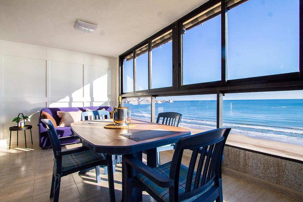 a dining room with a table and chairs and the ocean at 13 ESPACIO SOBRE MAR in Cullera