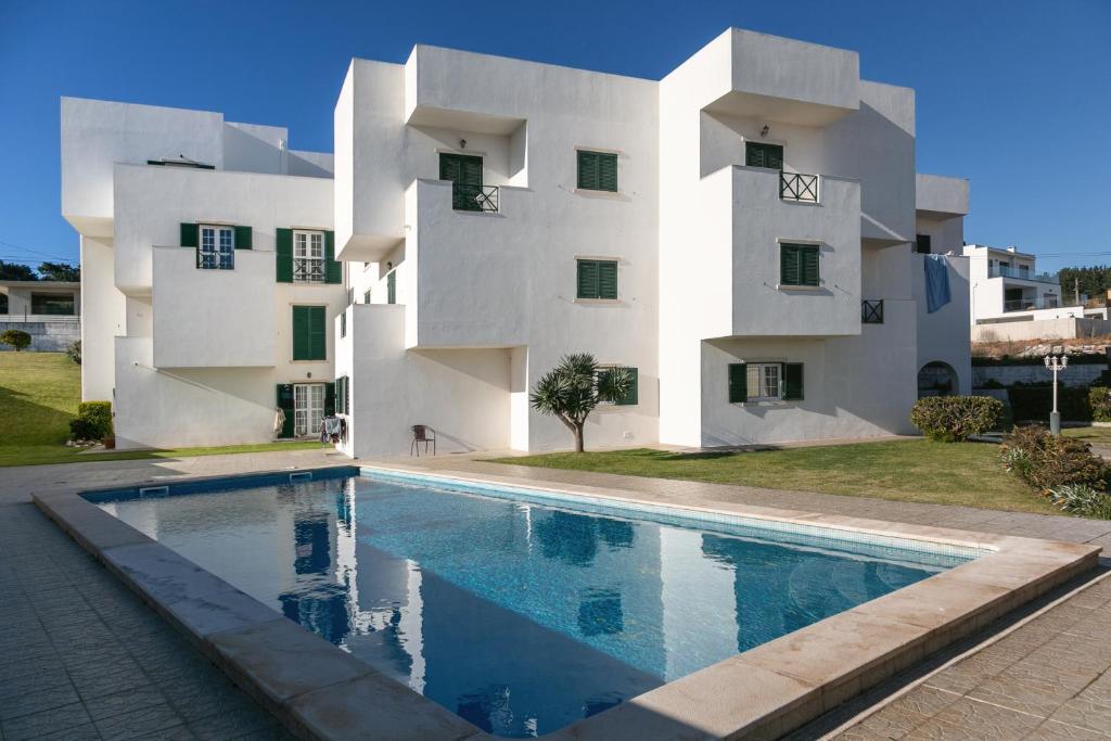 un edificio con una piscina di fronte a un edificio di Relax In Foz a Foz do Arelho