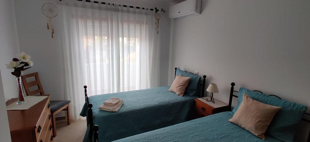 um quarto com 2 camas e uma janela em Cabana Formosa T2 Férias Cabanas de Tavira em Cabanas de Tavira