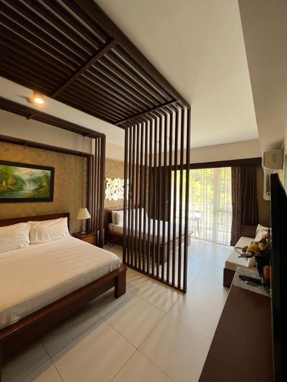 a bedroom with a large bed and a living room at Bonel condo at Pico de Loro in Cutad