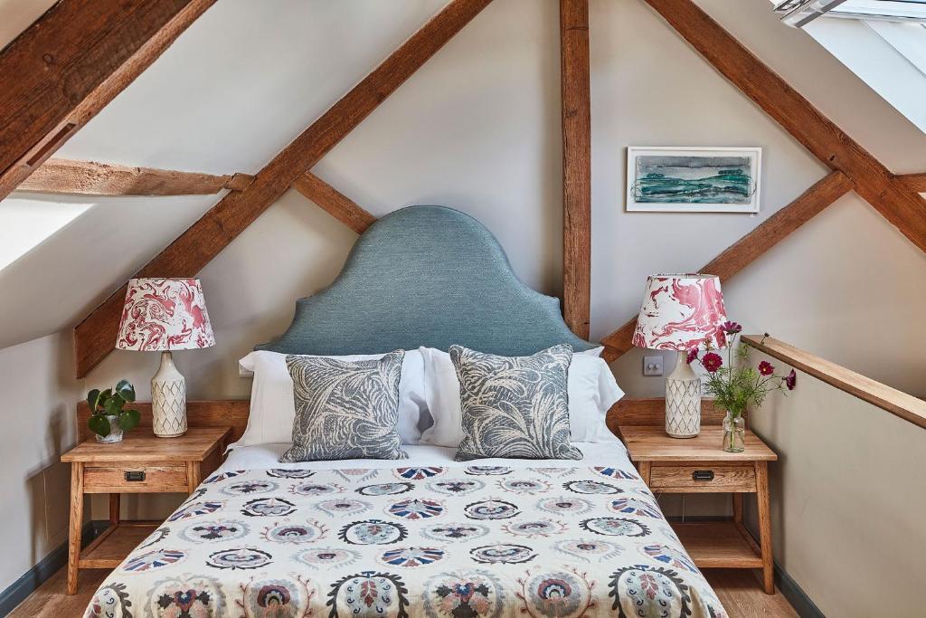 a bedroom with a bed with a blue headboard at The Farm at Avebury in Marlborough