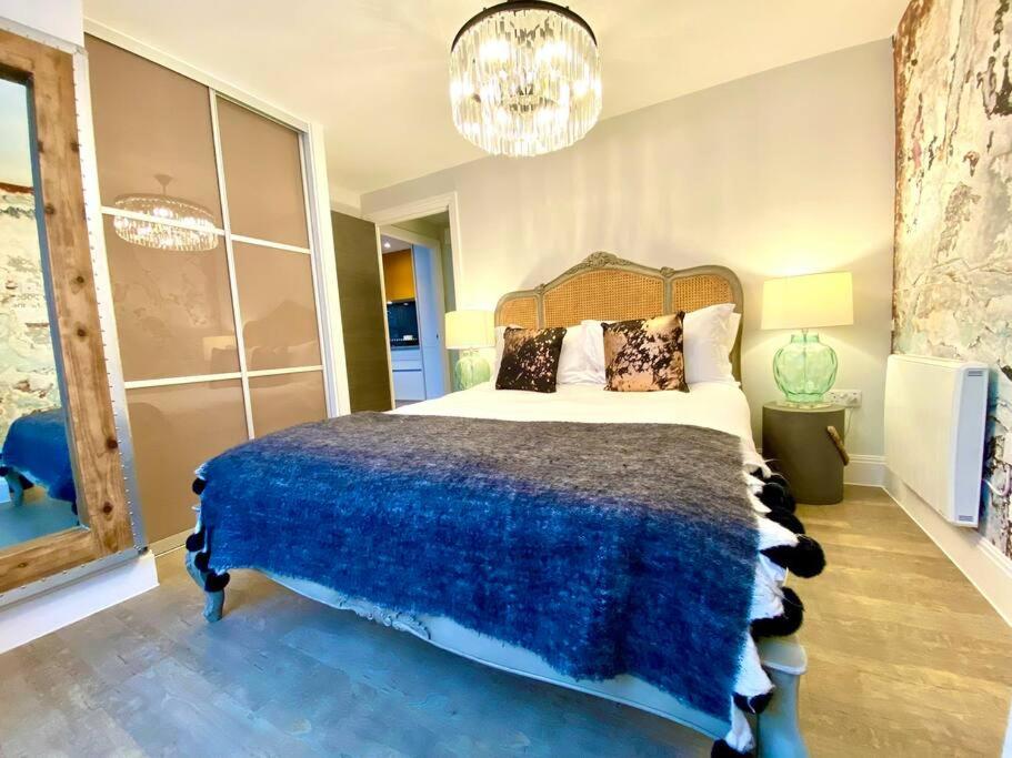 a bedroom with a large bed and a chandelier at Elegant Apartment - 1 Minute walk to Poole Quay - Great Location - Free Parking - Fast WiFi - Smart TV - Newly decorated - sleeps up to 2! Close to Poole & Bournemouth & Sandbanks in Poole