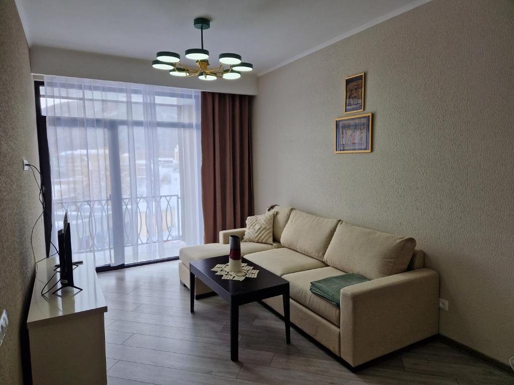 een woonkamer met een bank en een tafel bij Alvina apartment Tsaghkadzor in Tsachkadzor