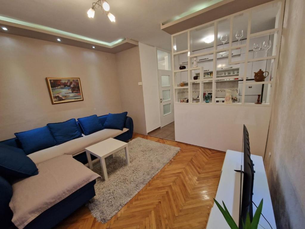 a living room with a blue couch and a table at Your place in Podgorica in Podgorica
