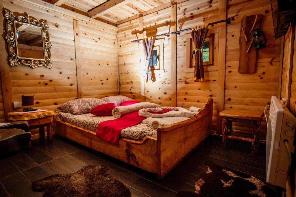 a bedroom with a bed in a log cabin at Kraljevsko selo Kotromanićevo in Doboj