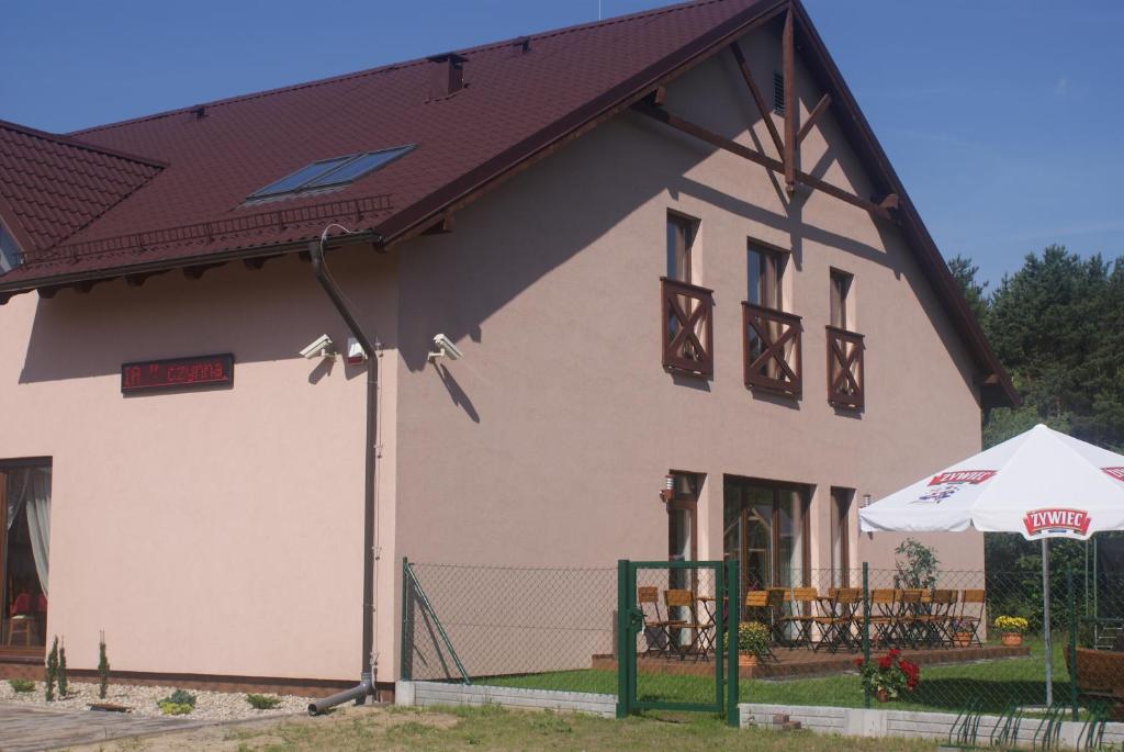 Casa blanca grande con techo marrón en U Hołosia, en Osowiec