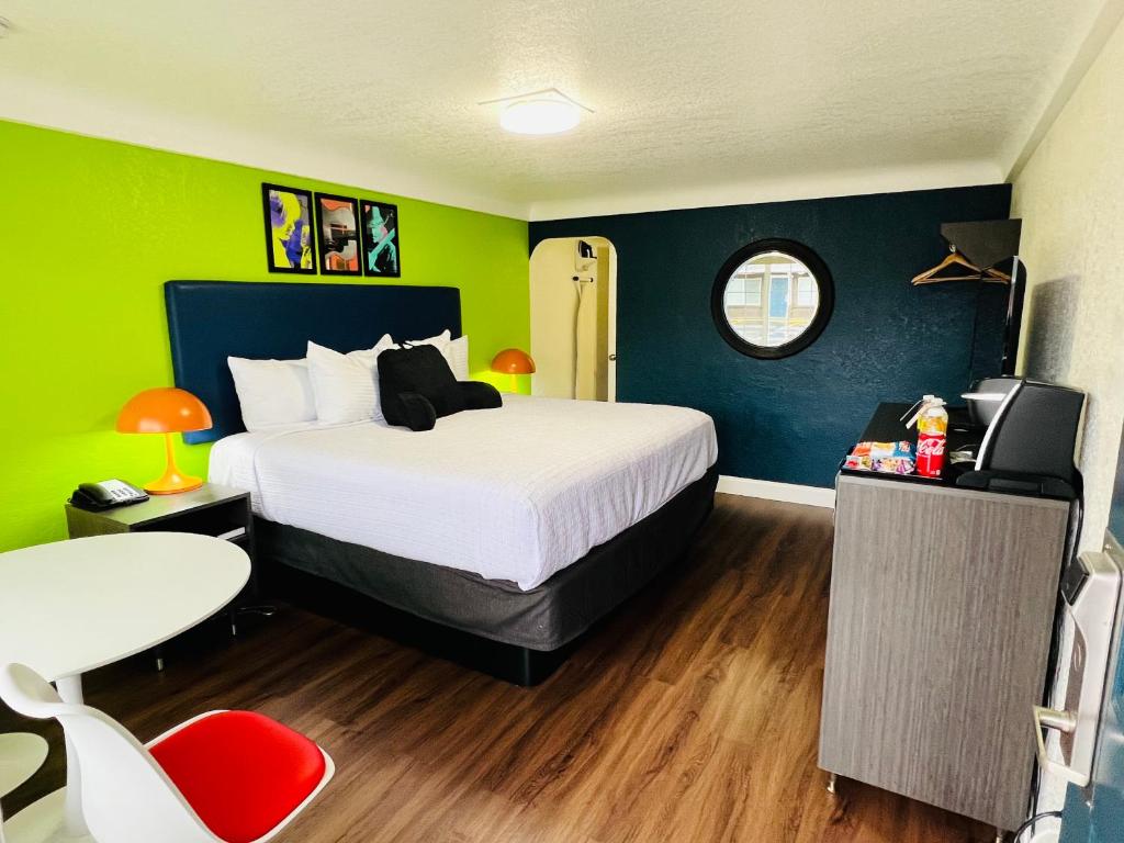 a bedroom with a bed and a green wall at Signature Inn Eugene in Eugene