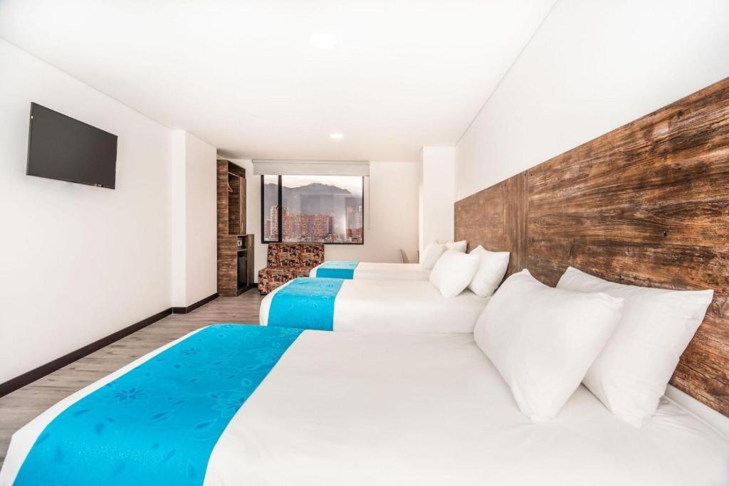 2 camas en una habitación de hotel con TV en HOTEL AMERICAN VISA CORPORATE, en Bogotá