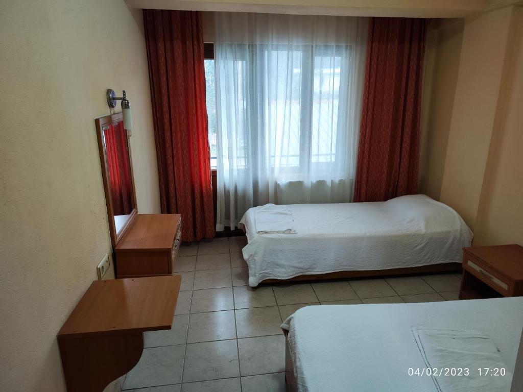 a hotel room with two beds and a window at Caner Mountain Hotel in Antalya