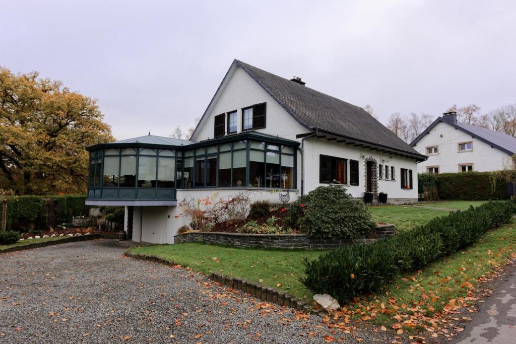 une maison blanche avec beaucoup de fenêtres dans l'établissement La colline aux hirondelles, à La-Roche-en-Ardenne