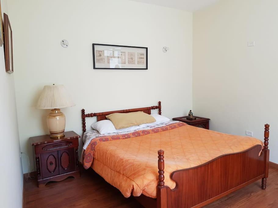 a bedroom with a bed and a lamp on a table at Beautiful & fully renovated flat in historic city center in Quito