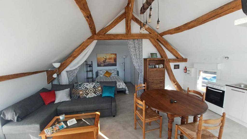 a living room with a couch and a table at L'appel de la foret in Lyons-la-Forêt