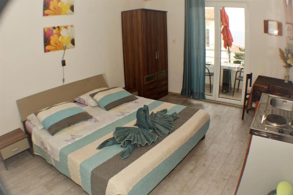 a bedroom with a large bed with towels on it at A1 tončev apartman in Igrane