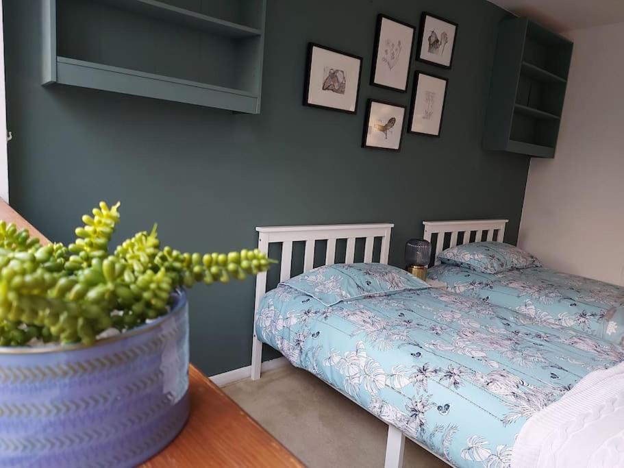 a bedroom with a bed and a table with a plant at 2 bed flat, Bounds Green, Piccadilly line, London N11 in London