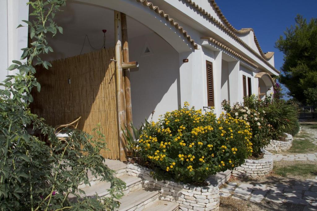 a house with flowers in front of a wooden gate at Oasi Beach Hotel in Vieste