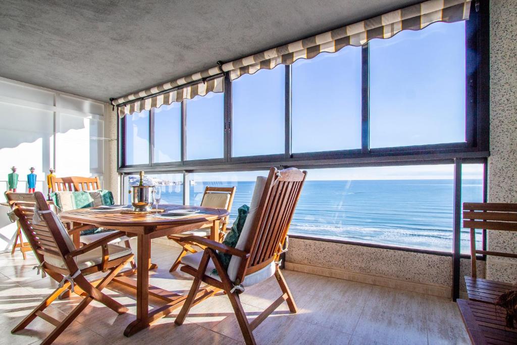 a dining room with a table and chairs and a large window at ESPACIO 16 - Primera LINEA PLAYA in Cullera