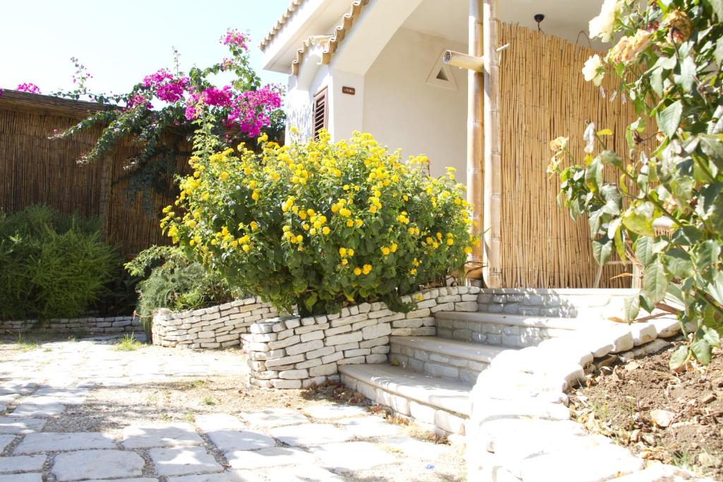 a garden with a retaining wall and stairs with flowers at Oasi Beach Hotel in Vieste