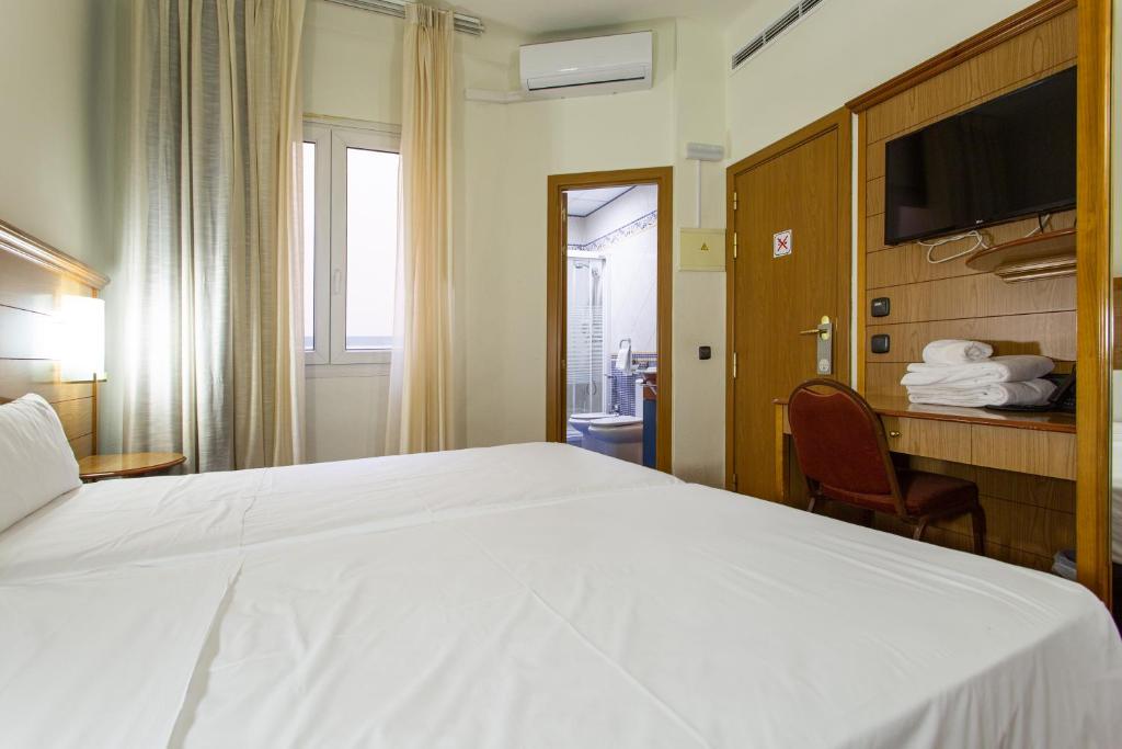 Postel nebo postele na pokoji v ubytování Negresco Gran Via