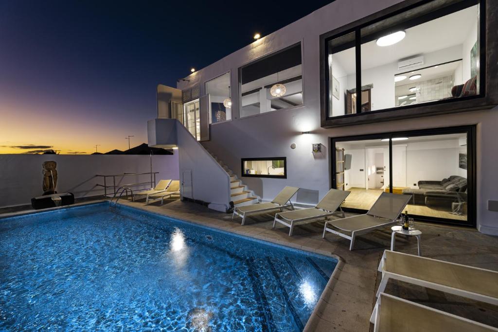 a villa with a swimming pool at night at Villa Atlantico - Planta Baja in Arrecife