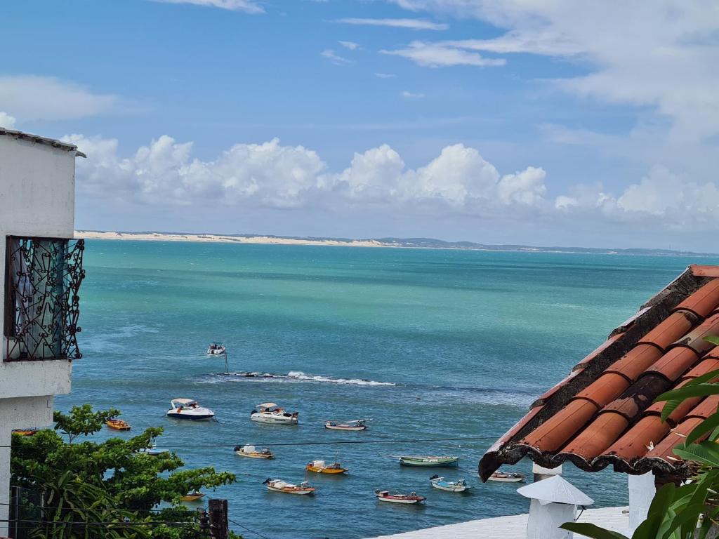 - une vue sur l'océan avec des bateaux dans l'eau dans l'établissement Casa de Dan, à Pipa