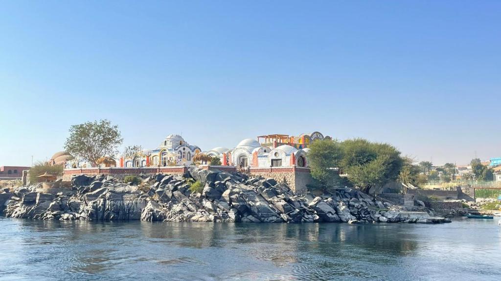 a group of houses on a rocky island in the water at Artika Wadi Kiki Hotel in Aswan