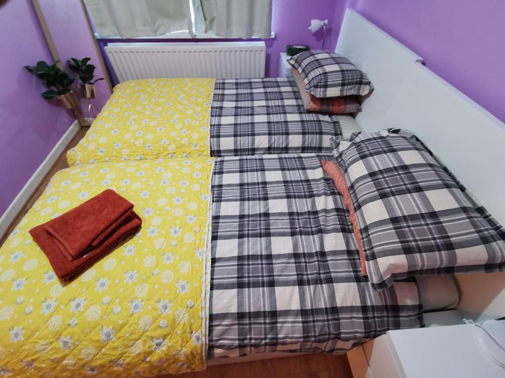 un letto giallo con una coperta sopra di Private Room in Coventry a Parkside