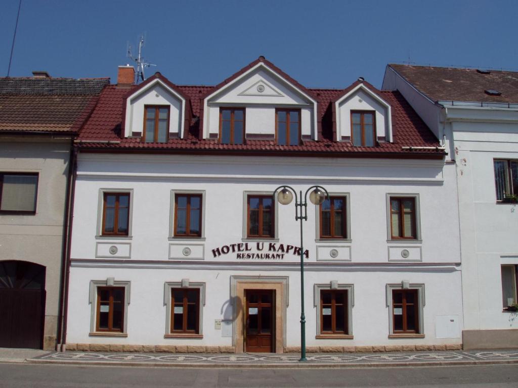 a white building with a red roof at Hotel u Kapra in Lázně Bělohrad