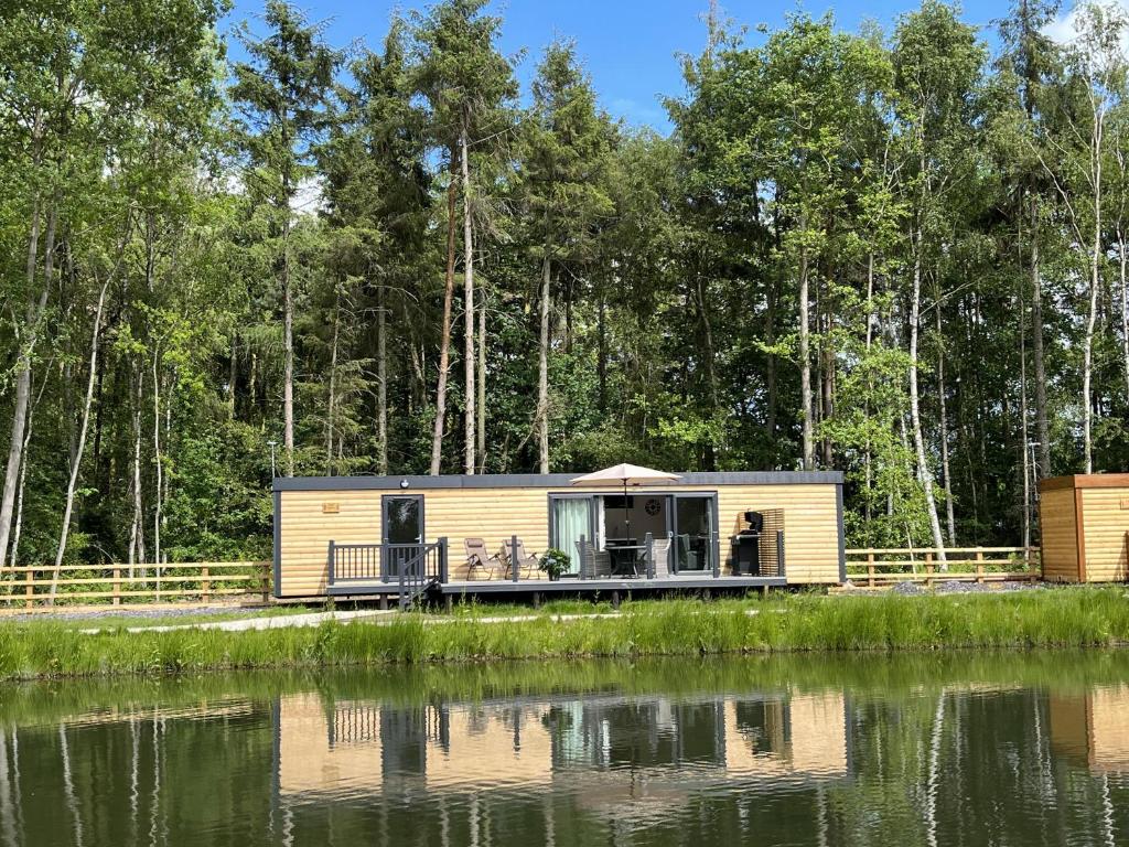 a cabin by a body of water at Pine Boutique Lodge with hot tub for couples & dog in York