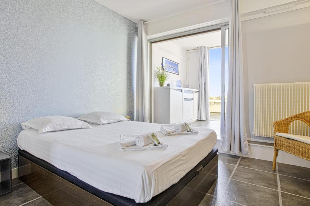 sypialnia z łóżkiem i dużym oknem w obiekcie Appartement Temerland - 4 étoiles - Welkeys w Biarritz