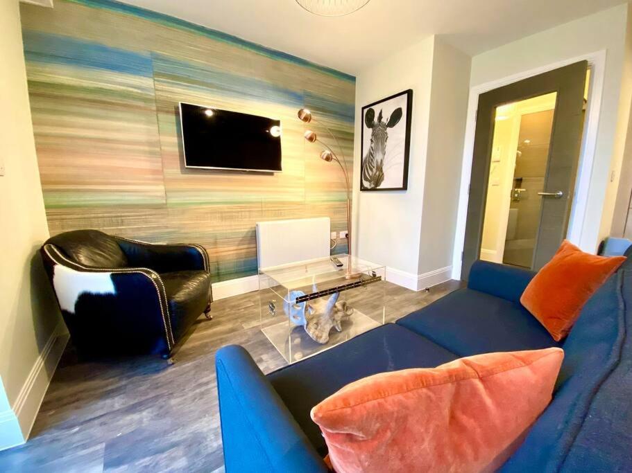 a living room with a blue couch and a tv at Stylish Apartment - 1 Minute walk to Poole Quay - Great Location - Free Parking - Fast WiFi - Smart TV - Newly decorated - sleeps up to 2! Close to Poole & Bournemouth & Sandbanks in Poole