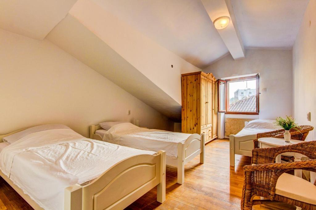 - une chambre avec 2 lits et une table dans l'établissement Guesthouse Natalija, à Pula