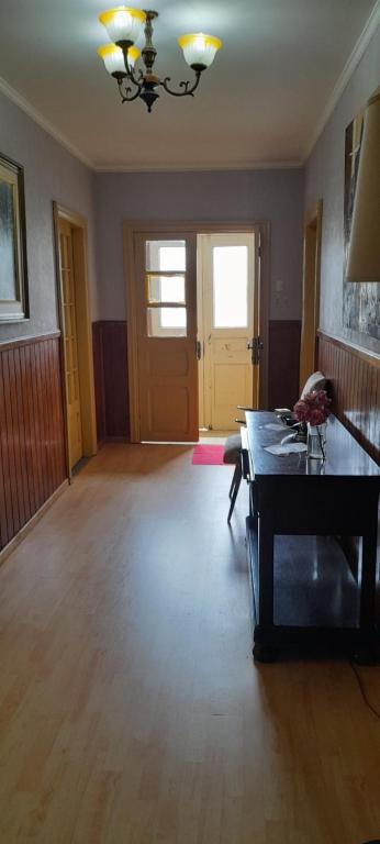 an empty living room with a table in the middle at Pensión al sur del.mundo in Punta Arenas