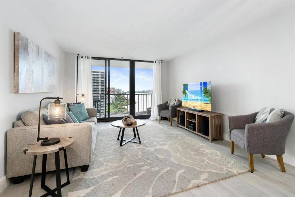 a living room with a couch and chairs and a tv at Sst3 #1209 in Marco Island